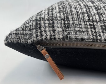 Puede incluir: Almohada con estampado en blanco y negro con un tirador de cremallera de cuero marrón que dice "HISA".