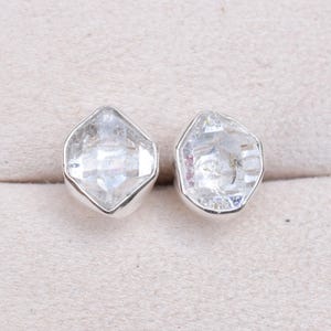May include: A pair of silver earrings with clear, faceted, octagonal-shaped gemstones.