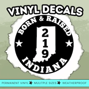 May include: A circular black and white vinyl decal featuring the text VINYL DECALS at the top and BORN & RAISED INDIANA at the bottom. The center displays a white silhouette of the state of Indiana with the number 219 and two white stars.