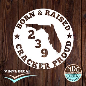 May include: White vinyl decal with a silhouette of the state of Florida and the text "Born & Raised Cracker Proud" in a circle. The numbers 239 are also included in the design.