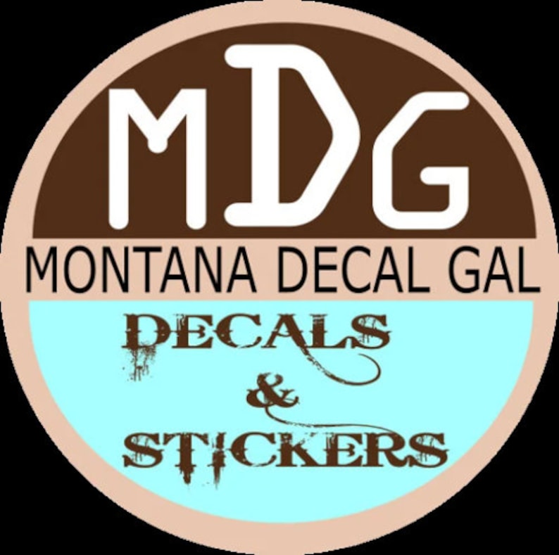 May include: A circular logo with the text "MDG" in white, set against a brown background. Below, it reads "MONTANA DECAL GAL" in white, with "DECALS & STICKERS" in a distressed font on a light blue background.