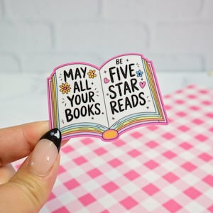 May include: Pink and white sticker with an open book design. The left page says "May all your books" and the right page says "Be five star reads".
