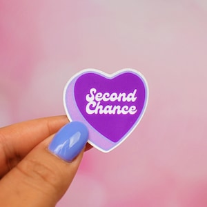 May include: Purple heart-shaped sticker with a white outline and the text "Second Chance" in a retro font.
