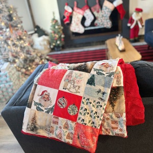 Peut inclure: Une courtepointe patchwork rouge, blanche et verte avec une variété d'images, y compris un Père Noël, un casse-noisette et un sapin de Noël. La courtepointe est en tissu de coton et a une sensation douce et confortable.