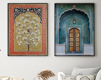 May include: Two framed prints, one with a floral design and the other with a blue and gold archway and door. The prints are hanging on a white wall above a light gray couch with pillows and a wooden coffee table.