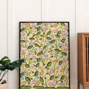 May include: A framed painting of a floral pattern with pink, blue, orange, and yellow flowers on a light yellow background. The flowers are surrounded by green leaves and stems.