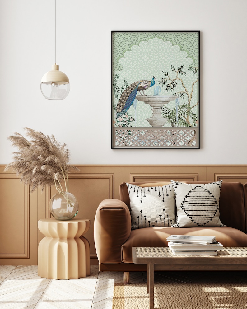 May include: A brown velvet sofa with two throw pillows, one with a black and white geometric pattern and the other with a black and white diamond pattern. A wooden coffee table with a woven top sits in front of the sofa. A framed print of a peacock standing on a fountain in a green and white garden hangs on the wall behind the sofa.