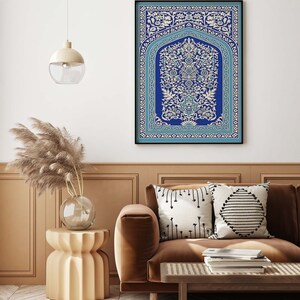 Puede incluir: Una impresi&oacute;n enmarcada de un dise&ntilde;o floral azul y blanco con detalles intrincados. La impresi&oacute;n est&aacute; colgada en una pared blanca sobre un sof&aacute; marr&oacute;n con almohadas.
