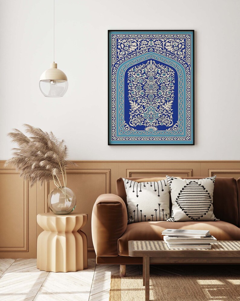 Puede incluir: Una impresi&oacute;n enmarcada de un dise&ntilde;o floral azul y blanco con detalles intrincados. La impresi&oacute;n est&aacute; colgada en una pared blanca sobre un sof&aacute; marr&oacute;n con almohadas.