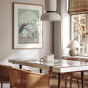 May include: A framed print of a peacock standing on a fountain with a green and blue background. The print is hanging on a white wall in a dining room with a wooden table and chairs.