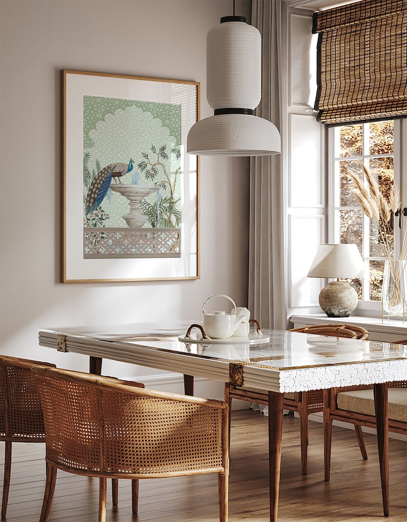 May include: A framed print of a peacock standing on a fountain with a green and blue background. The print is hanging on a white wall in a dining room with a wooden table and chairs.