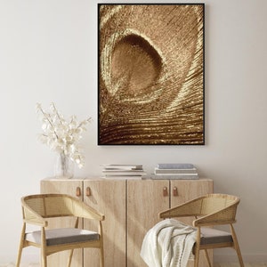 May include: A framed abstract print with a swirling pattern in shades of brown and gold. The print is hanging on a white wall above a wooden cabinet with two chairs.