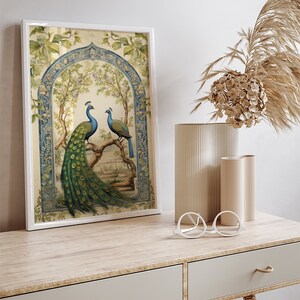 May include: A framed print of two peacocks in a blue and green archway with a floral background.