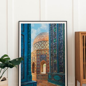 Pu&ograve; includere: Una stampa incorniciata di un edificio colorato e decorato con un esterno in piastrelle blu e una cupola dorata. L'edificio &egrave; circondato da un cortile con un cielo blu sullo sfondo.