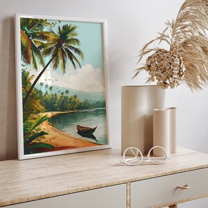 May include: A framed print of a tropical beach scene with palm trees, a sandy shore, and a small boat in the water. The print is in a white frame and is hanging on a wall.
