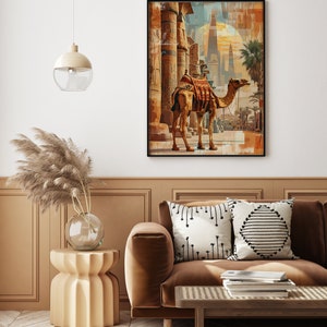 May include: A framed print of a camel standing in front of a large, ancient structure with pillars. The camel is brown and has a saddle on its back. The structure is made of stone and has intricate carvings. The background is a hazy blue and orange.