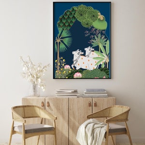 May include: A framed illustration of two white cows with black spots standing in a lush green forest. The cows are surrounded by trees and flowers, and the background is a deep blue color.