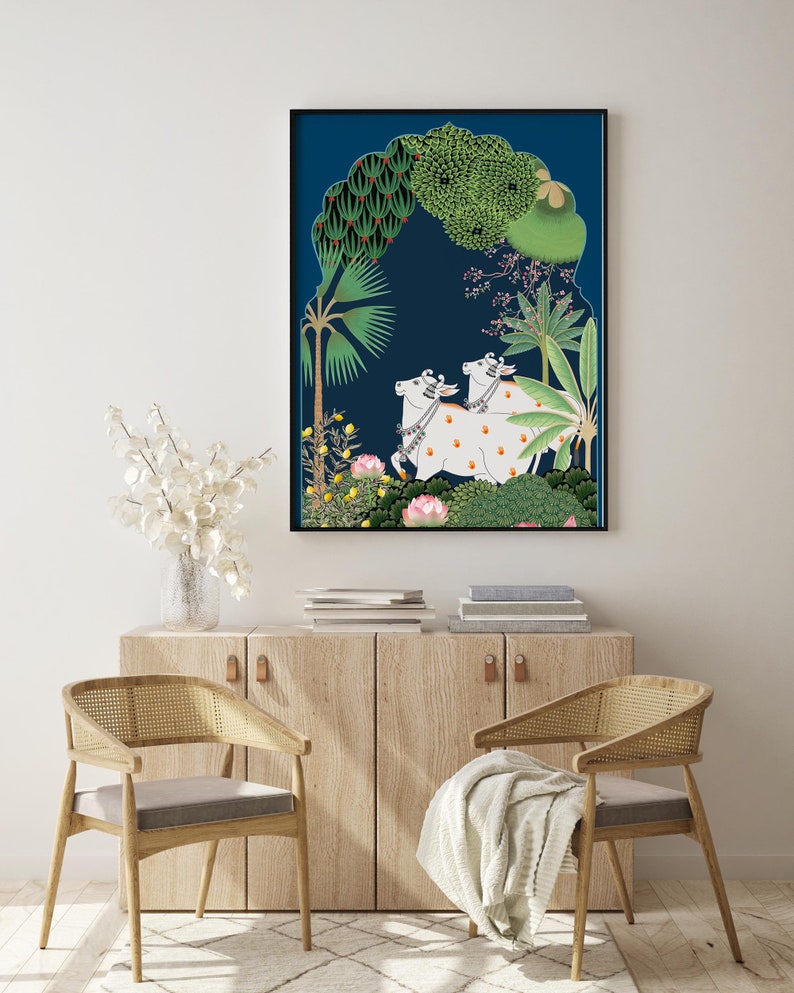May include: A framed illustration of two white cows with black spots standing in a lush green forest. The cows are surrounded by trees and flowers, and the background is a deep blue color.