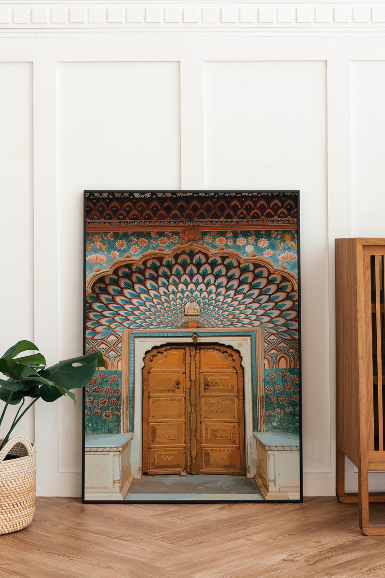 May include: Framed art print featuring a detailed illustration of an ornate, golden door. The artwork showcases intricate patterns in teal, orange, and brown, with a peacock feather design above the door. The print is displayed on a wooden floor.