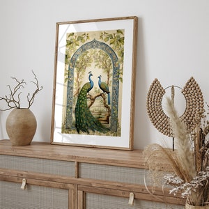May include: A framed print of two peacocks perched on a branch in a decorative archway. The peacocks are blue and green with intricate tail feathers. The background is a light green with floral details.