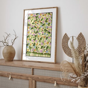 May include: A framed print of a colorful floral pattern with pink, blue, yellow, and green flowers on a yellow background. The print is in a wooden frame.