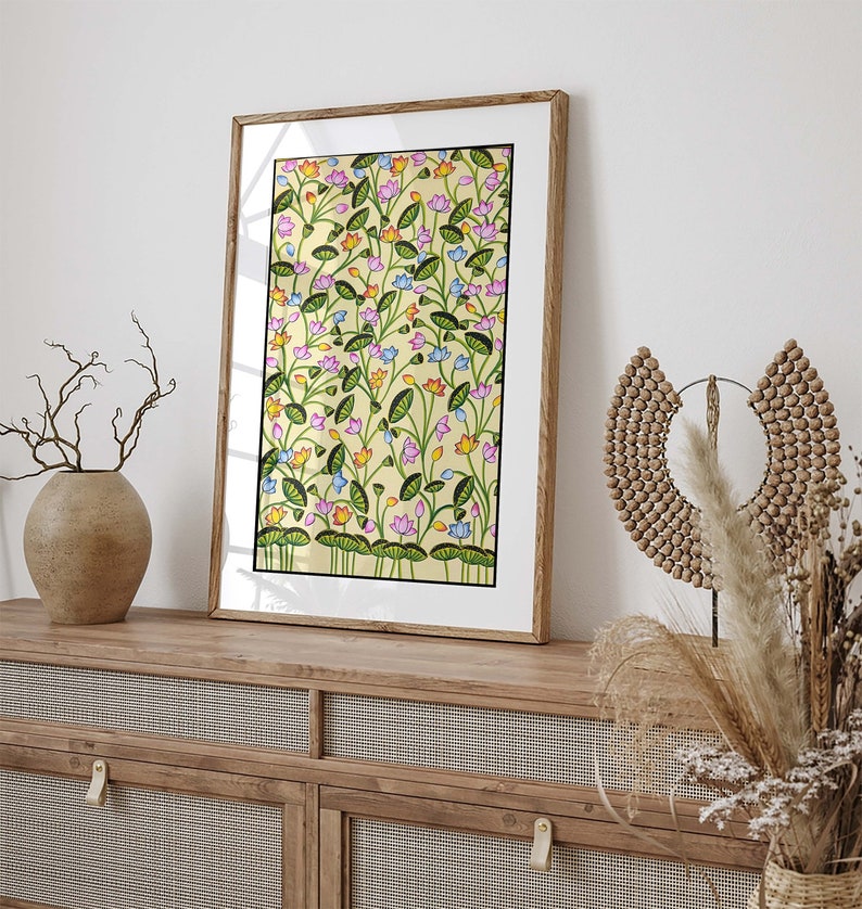 May include: A framed print of a colorful floral pattern with pink, blue, yellow, and green flowers on a yellow background. The print is in a wooden frame.