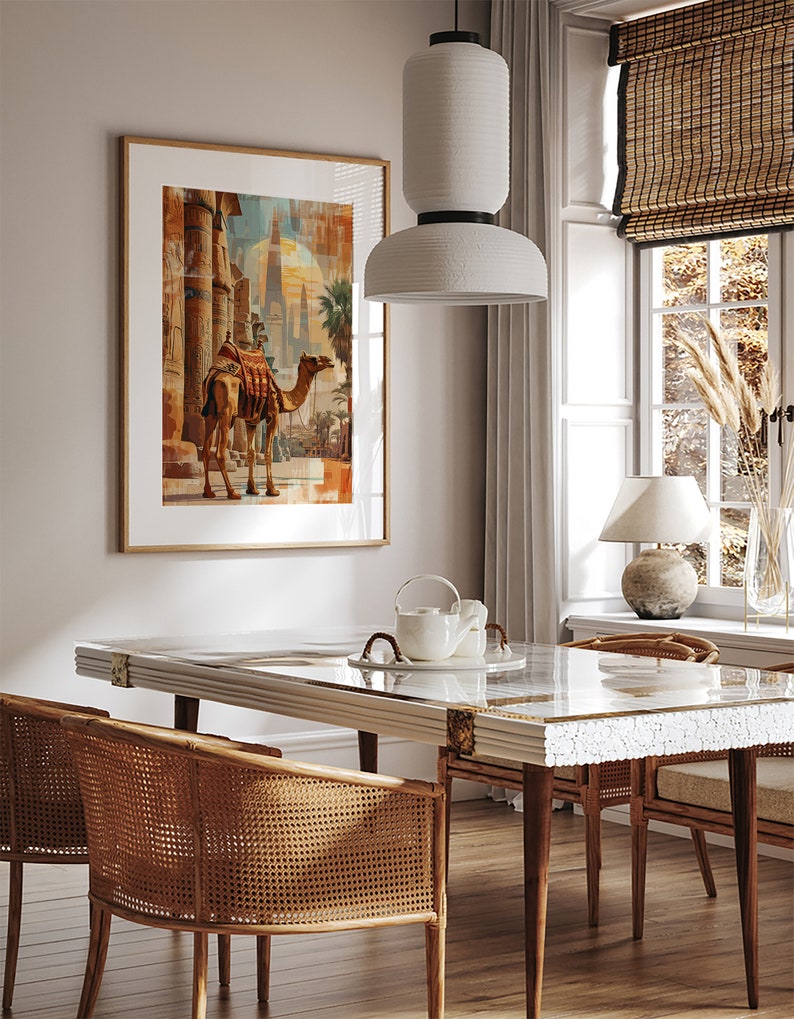 May include: A dining room with a white marble table and four wicker chairs. A white pendant light hangs above the table. A framed print of a camel in front of a building is on the wall.