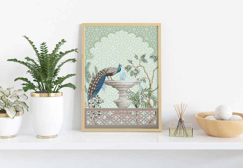 May include: A framed print of a peacock standing on a fountain in a green and white garden. The print has a decorative border with a geometric pattern.