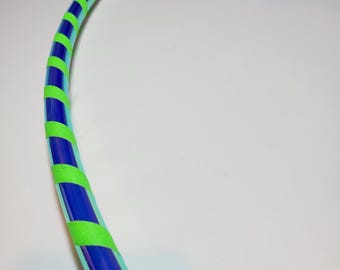 Può includere: Un cerchio iridescente blu e verde con nastro verde avvolto intorno.