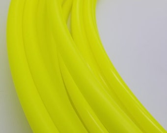 May include: Close-up of a bright yellow hula hoop, showing the smooth, shiny surface of the plastic.