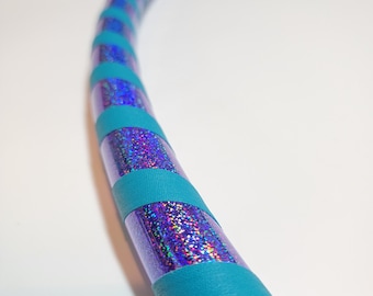 Può includere: Un cerchio hula di colore turchese e viola iridescente con una finitura scintillante. Il cerchio è in plastica e ha un diametro di circa 91 cm.