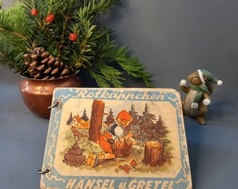 Antiguo libro de cuentos de hadas con gruesas páginas de cartón.