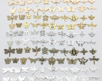 Könnte beinhalten: Eine Sammlung von Metallanhängern in verschiedenen Formen wie Schmetterlingen, Libellen und Bienen. Die Anhänger sind in Gold-, Silber- und Bronzetönen gehalten und verfügen jeweils über eine kleine Öse zur Befestigung an Schmuckstücken.