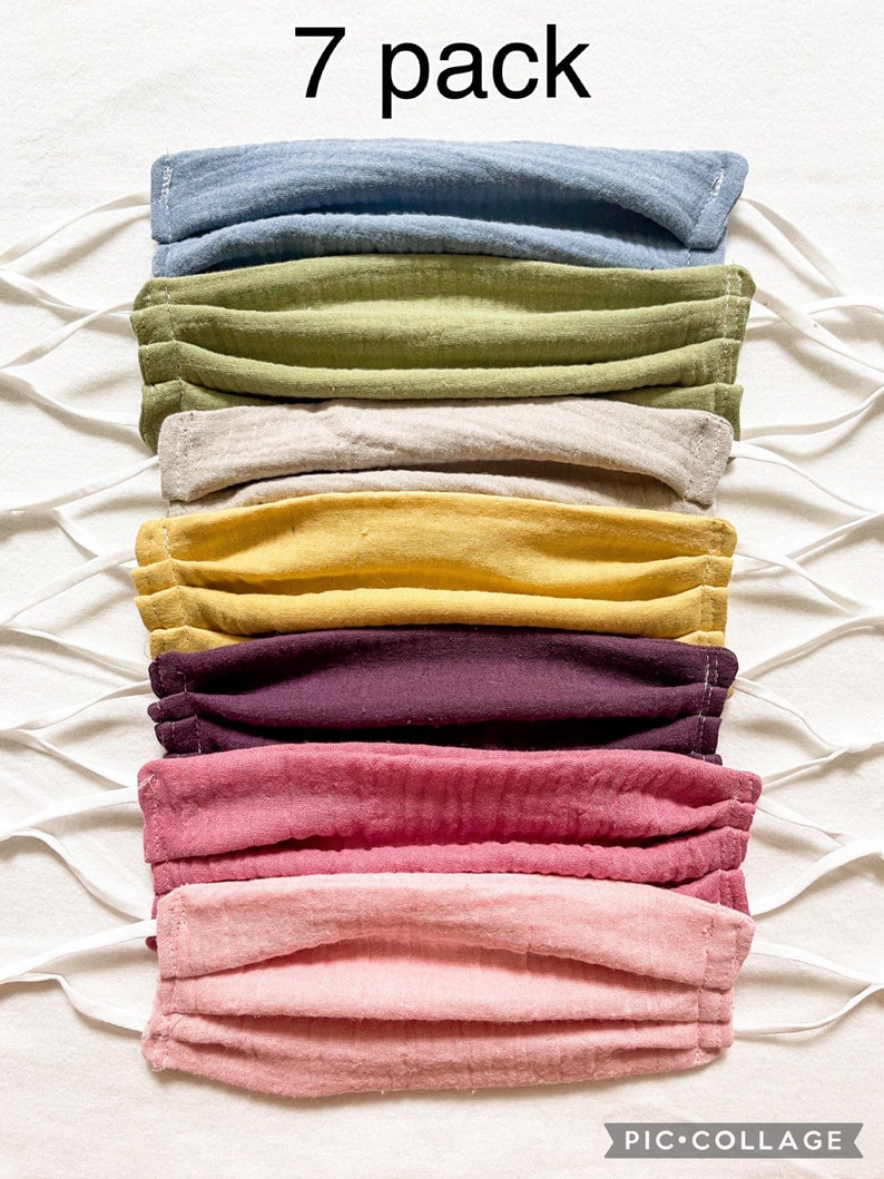 May include: A 7 pack of face masks in various colors, including blue, green, beige, yellow, purple, pink, and light pink. The masks are made of a soft, breathable fabric and have elastic ear loops.