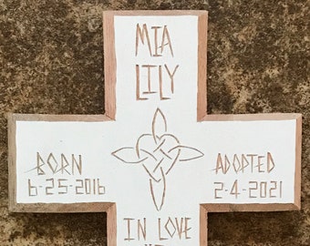 Könnte beinhalten: Weißes Holzkreuz mit den Namen Mia Lily, den Daten 6-25-2016 und 2-4-2021 sowie dem Text "In love he predestined us to be adopted as his children through Jesus Christ Eph 1:5".