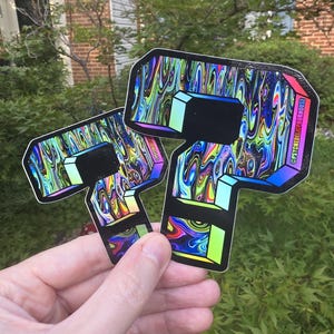 May include: Two question mark shaped stickers featuring a holographic, swirling multi-colored pattern with black outlines and blocky, three-dimensional edges. The text @PSYCHEDELICPOURHOUSE is printed in small white letters along the right side edge.
