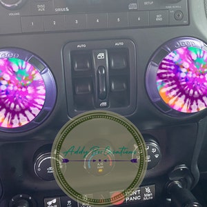 May include: Two tie-dye patterned car knob covers with the word "Jeep" printed on them. The covers are pink, purple, orange, and green.