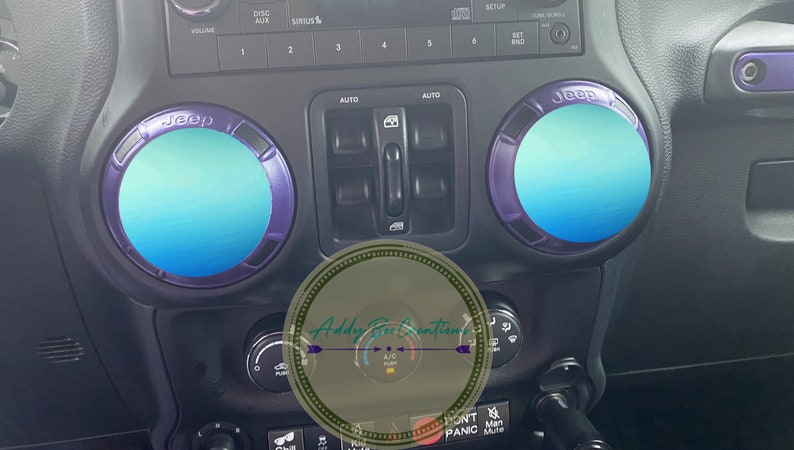 Puede incluir: Primer plano del interior de un Jeep con dos anillos de acento del logotipo de Jeep azul y morado. Los anillos est&aacute;n en el tablero y tienen un color azul degradado.