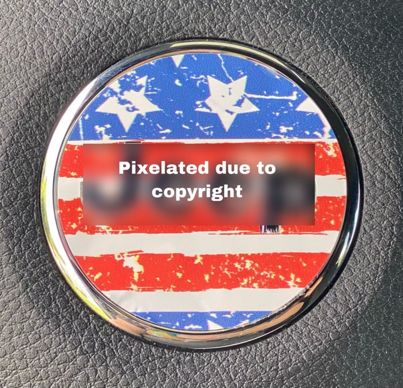 May include: A round, silver-rimmed sticker with a distressed American flag design. The sticker has red and white stripes and blue stars. The text "Pixelated due to copyright" is visible in the center of the sticker.