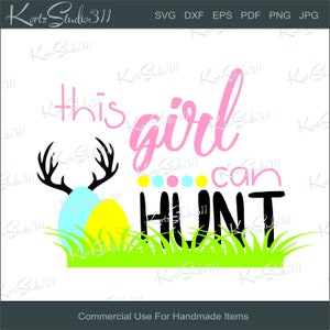 Peut inclure: Un design graphique rose et noir avec le texte "This girl can hunt" et une paire de bois de cerf avec deux œufs de Pâques devant eux. Les œufs sont bleus et jaunes et sont entourés d'herbe verte.
