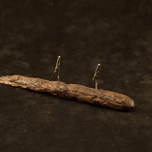 May include: A rustic wooden stand with two metal clips, perfect for holding photos or notes.