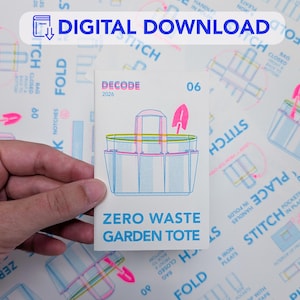 Può includere: Una carta rettangolare bianca con la grafica di una borsa da giardino con contorni blu e rosa, un'icona di una cazzuola rosa e il testo DECODE 06 ZERO WASTE GARDEN TOTE. La carta è tenuta contro uno sfondo di istruzioni di cucito stampate.