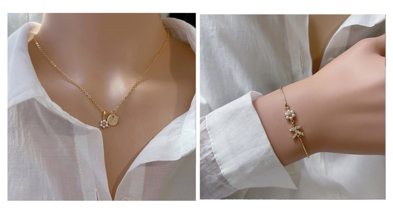 May include: A gold necklace with a small flower charm and a round pendant. A gold bracelet with a flower charm and a letter charm.