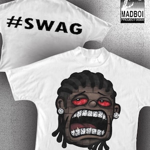 May include: White t-shirt with a graphic of a cartoon face with red eyes, diamond teeth, and earrings. The back of the shirt has the text "#SWAG". The shirt also has the "MADBOI PROJECT 00000" logo.
