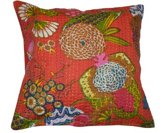 May include: A red, floral patterned pillow with a quilted design. The pillow features a variety of flowers in shades of pink, blue, green, and brown.