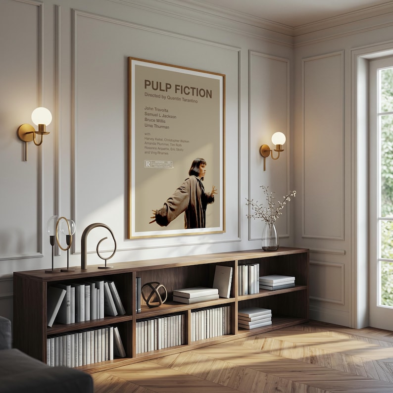 K&ouml;nnte beinhalten: Ein gerahmtes "Pulp Fiction"-Filmplakat h&auml;ngt &uuml;ber einem dunklen Holzregal voller B&uuml;cher. Das Plakat zeigt den Filmtitel und die Besetzung, mit einem Bild von Uma Thurman. Zwei goldene Wandleuchten flankieren das Plakat.