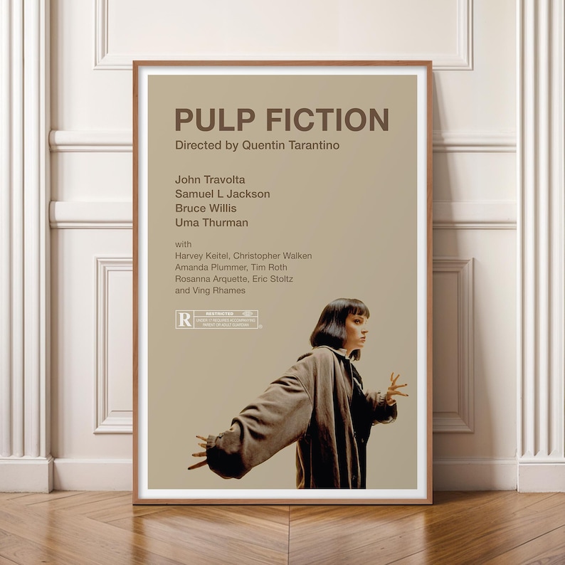 K&ouml;nnte beinhalten: Ein gerahmtes Filmplakat f&uuml;r "Pulp Fiction" mit einem braunen Holzrahmen. Das Plakat zeigt den Filmtitel, den Regisseur und die Besetzung, darunter John Travolta und Uma Thurman. Das Bild zeigt eine Frau in einem braunen Mantel.