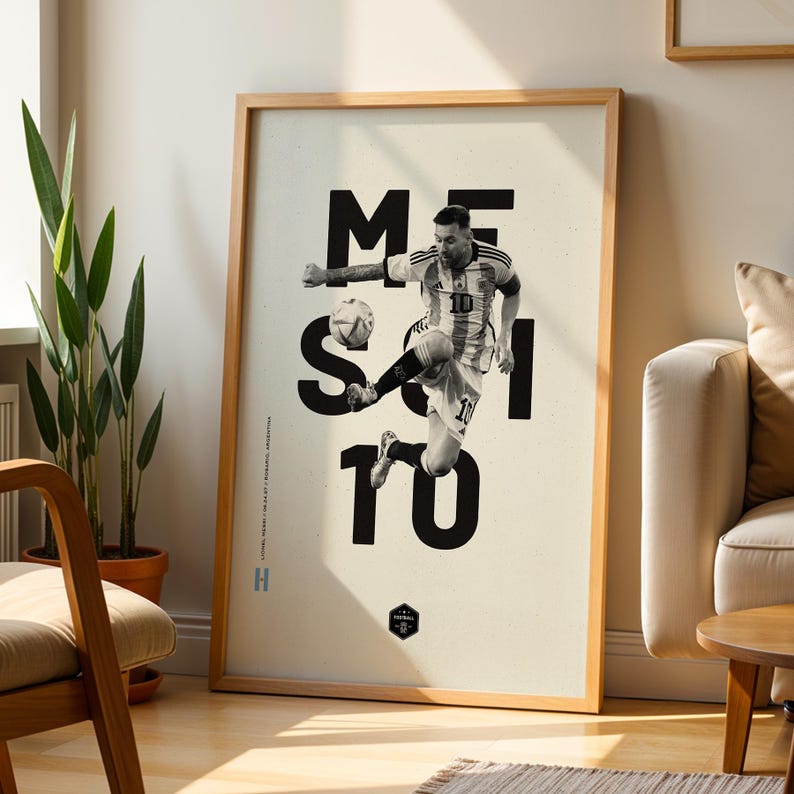 May include: Framed poster featuring a black and white image of a soccer player in action, kicking a ball. The word "MESSI" is displayed in large, bold, black letters. The player is wearing a soccer uniform with the number 10. The poster is in a wooden frame.
