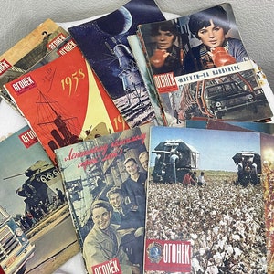 Könnte beinhalten: Ein Stapel russischer Vintage-Magazine mit dem Titel "OGONYOK" auf den Deckblatt. Die Magazine zeigen verschiedene Bilder, darunter ein Schiff, ein Auto, ein Baumwollfeld und eine Rakete.