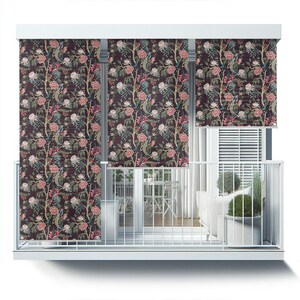 May include: A balcony with white railings and a white ceiling. Three window shades with a floral pattern are pulled down. The shades feature a dark brown background with pink flowers, green leaves, and blue birds.